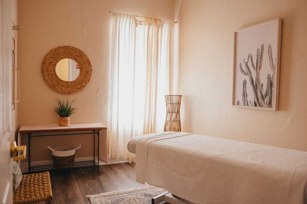 Massage room with table, soothing decor, and soft natural light.