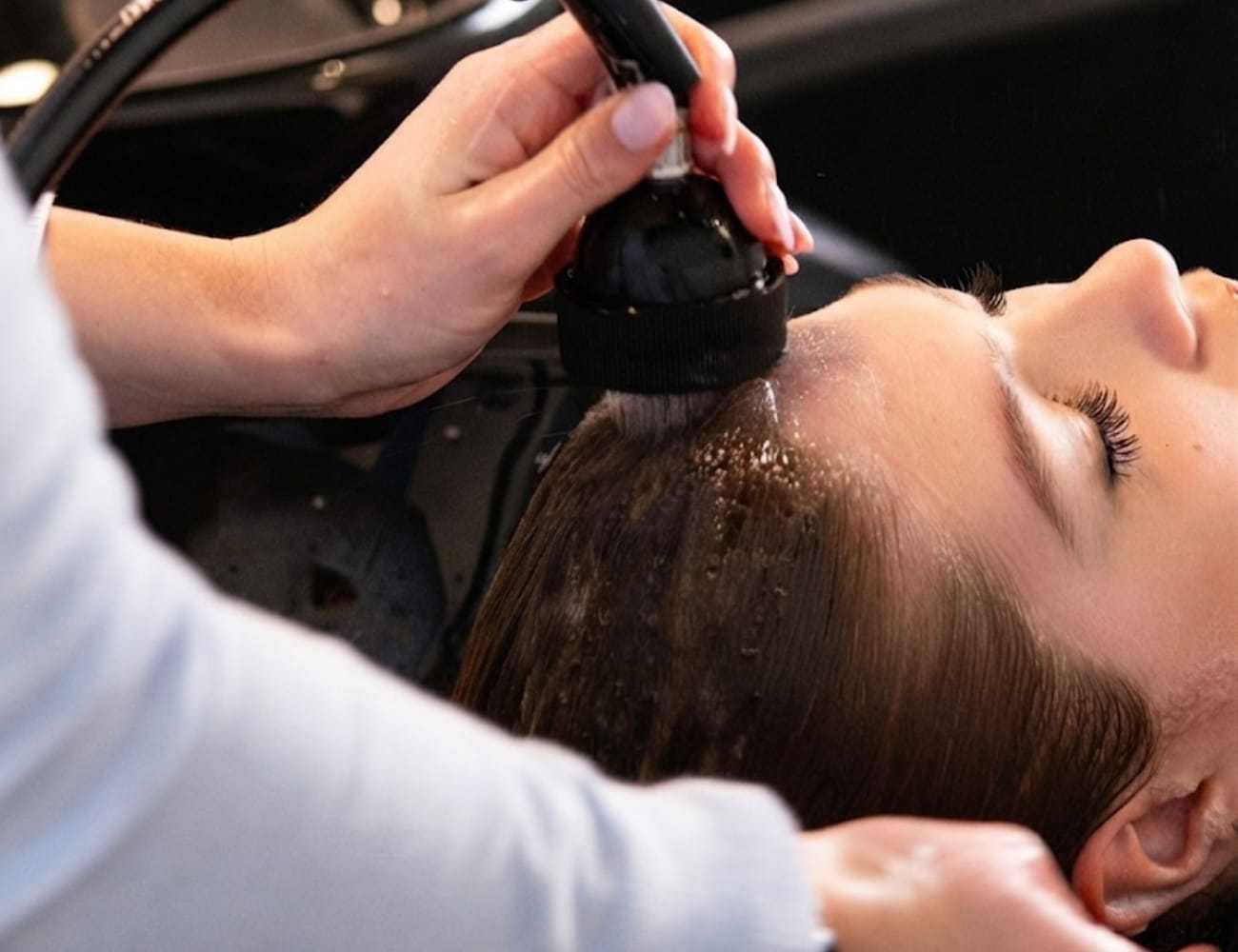 Person getting hair washed at a salon sink.